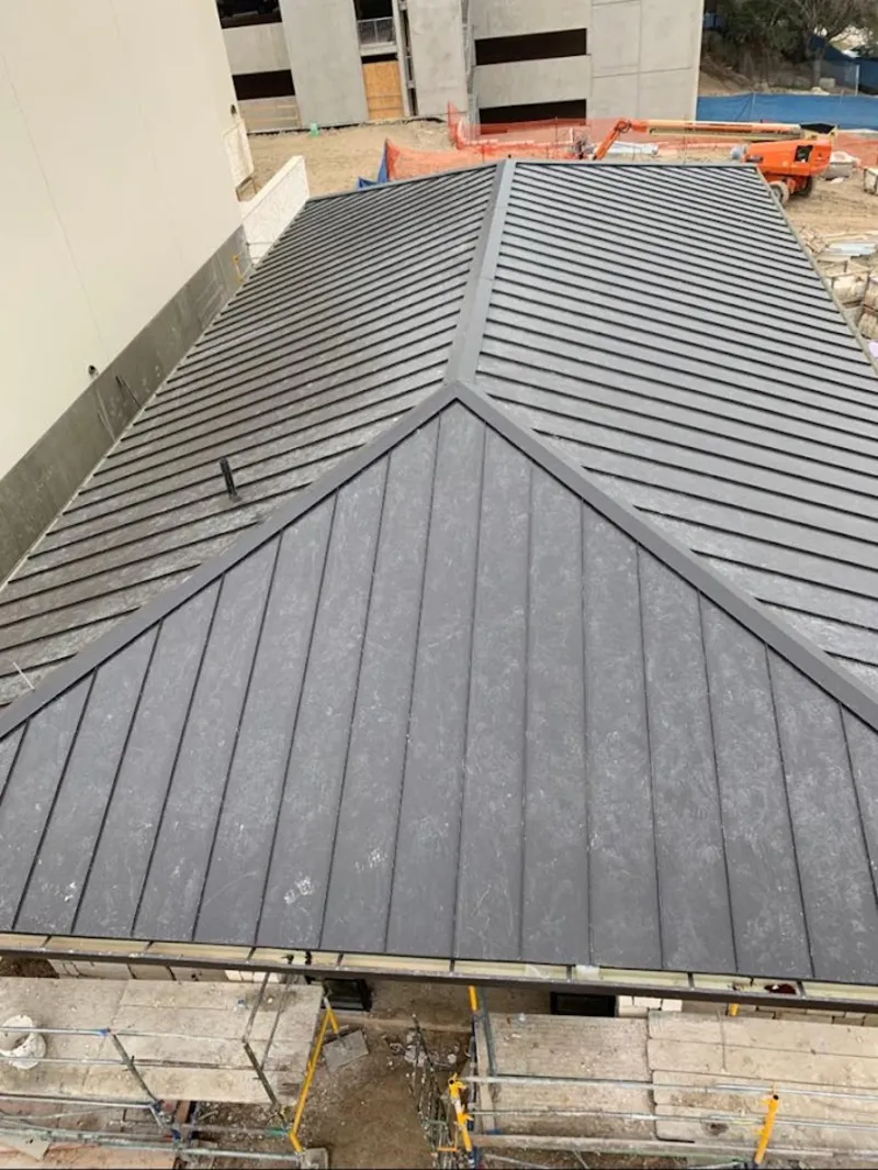 Commercial metal roof construction with crane equipment in Beeville